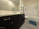 Modern bathroom with black cabinets, white countertops, tub-shower combo, and neutral toned floors at 2727 N Acacia Way, Buckeye, AZ 85396