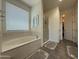 Spa-like bathroom featuring a soaking tub under a window and a glass-enclosed shower at 2727 N Acacia Way, Buckeye, AZ 85396