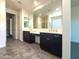 Bathroom featuring double sinks, a large mirror and dark wood cabinets at 2727 N Acacia Way, Buckeye, AZ 85396
