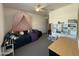 Cozy bedroom featuring a comfortable daybed with pink canopy and a practical desk with storage at 2727 N Acacia Way, Buckeye, AZ 85396