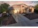 Beautiful single-Gathering home boasting a stone facade, ample driveway space, and well-maintained landscaping at 2727 N Acacia Way, Buckeye, AZ 85396