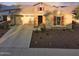 Inviting single-Gathering home with stone accents, lush landscaping, and a spacious driveway leading to a two-car garage at 2727 N Acacia Way, Buckeye, AZ 85396
