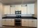 Close up view of the kitchen, showing stainless steel appliances and white shaker cabinets at 2727 N Acacia Way, Buckeye, AZ 85396