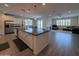 Open kitchen with a large island, stainless steel appliances, and tile flooring that flows into the living area at 2727 N Acacia Way, Buckeye, AZ 85396