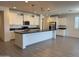 Bright kitchen features a large island, stainless steel appliances, and modern white cabinetry at 2727 N Acacia Way, Buckeye, AZ 85396