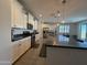 Bright kitchen with white cabinetry, stainless steel appliances, dark countertops, and an island, open to the dining area at 2727 N Acacia Way, Buckeye, AZ 85396