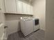 Functional laundry room with modern washer and dryer units, along with ample storage at 2727 N Acacia Way, Buckeye, AZ 85396