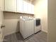 Laundry room featuring white appliances and matching wall cabinets for storage at 2727 N Acacia Way, Buckeye, AZ 85396