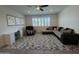Comfortable living room featuring a sectional sofa, recliner, patterned rug, and natural light from a window with shutters at 2727 N Acacia Way, Buckeye, AZ 85396
