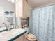 Well-lit bathroom with a white sink and cabinet, sea-themed decor, and a sailboat-patterned shower curtain at 3104 E Broadway Rd # 212, Mesa, AZ 85204
