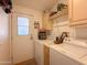 Functional laundry room with washer, dryer, and storage cabinets; door to outside at 3104 E Broadway Rd # 212, Mesa, AZ 85204