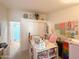 Bright office with a work table, storage shelves, pink chair, and view to a bathroom at 3104 E Broadway Rd # 212, Mesa, AZ 85204