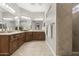 Primary bathroom featuring dual vanities, neutral tile flooring, and a glass block window at 31703 N 15Th Dr, Phoenix, AZ 85085