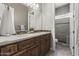 Bathroom featuring double sinks, wood cabinets, and a shower with a glass block window at 31703 N 15Th Dr, Phoenix, AZ 85085