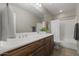 Bathroom boasts a wooden vanity with white countertops, a tub, and shower at 31703 N 15Th Dr, Phoenix, AZ 85085