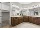 Primary bathroom featuring dual vanities, neutral tile flooring, and access to the walk-in closet at 31703 N 15Th Dr, Phoenix, AZ 85085