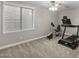 Bedroom with a large window and carpeted floors featuring a treadmill and stationary bike at 31703 N 15Th Dr, Phoenix, AZ 85085