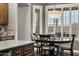Cozy dining area features dark wood table, grey chairs, and stylish lighting fixture with desert views through shuttered windows at 31703 N 15Th Dr, Phoenix, AZ 85085