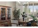 Elegant dining area with a wooden table, six chairs, stylish light fixture and beautiful window shutters at 31703 N 15Th Dr, Phoenix, AZ 85085