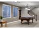 Spacious game room featuring a billiard table, staircase, and two large windows at 31703 N 15Th Dr, Phoenix, AZ 85085