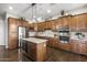 Modern kitchen with stainless steel appliances, wooden cabinets, and a center island with bar seating at 31703 N 15Th Dr, Phoenix, AZ 85085
