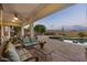Spacious covered patio with comfortable seating, a fire pit, and desert landscaping beyond at 31703 N 15Th Dr, Phoenix, AZ 85085