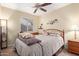 Cozy bedroom featuring a ceiling fan, a comfortable bed with a wooden headboard and a window with blinds at 3207 E Behrend Dr, Phoenix, AZ 85050