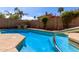 Inviting backyard pool with clear blue water, surrounded by landscaping, stone accents, and a block wall at 3207 E Behrend Dr, Phoenix, AZ 85050