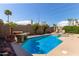 Backyard pool surrounded by a block wall, palm trees and lounge chairs at 3207 E Behrend Dr, Phoenix, AZ 85050
