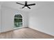 Light filled bedroom boasting hardwood floors, a modern ceiling fan, and an arched window at 3307 N Apollo Dr, Chandler, AZ 85224