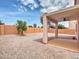 Gravel backyard with block wall fencing and a covered patio area, and a small young tree at 3421 S 256Th Ave, Buckeye, AZ 85326