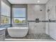 Bright bathroom features a luxurious tub, tiled walk-in shower, and a large window providing great natural light at 3421 S 256Th Ave, Buckeye, AZ 85326