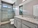 Tiled bathroom features a gray vanity with granite counters and a glass-enclosed shower creating a sleek and modern aesthetic at 3421 S 256Th Ave, Buckeye, AZ 85326