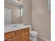 Cozy half bathroom featuring warm paint, wood vanity, white sink, and a framed mirror at 3421 S 256Th Ave, Buckeye, AZ 85326
