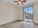 This bedroom features wood-look floors, ceiling fan, and sliding glass door to the patio at 3421 S 256Th Ave, Buckeye, AZ 85326
