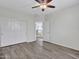 This bedroom features wood-look floors, ceiling fan, and closet with sliding doors at 3421 S 256Th Ave, Buckeye, AZ 85326