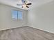 Well-lit bedroom with wood-look flooring and a window, offering a calming and neutral space at 3421 S 256Th Ave, Buckeye, AZ 85326