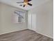 Well-lit bedroom with wood-look flooring, neutral walls, and a window, creating a calming and inviting atmosphere at 3421 S 256Th Ave, Buckeye, AZ 85326