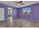 View of bedroom leading into bathroom featuring a large window and a ceiling fan at 3421 S 256Th Ave, Buckeye, AZ 85326