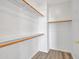 Bright walk-in closet with built-in shelving and wooden rods, perfect for organizing clothes and accessories at 3421 S 256Th Ave, Buckeye, AZ 85326