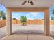 Covered patio area that looks out into the gravel backyard with block wall fencing and a young tree at 3421 S 256Th Ave, Buckeye, AZ 85326