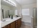 Bathroom features dual sinks, a soaking tub, and a glass-enclosed shower at 35624 N Zachary Rd, San Tan Valley, AZ 85144