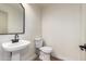 Powder room featuring a modern pedestal sink, toilet and a sleek black framed mirror at 3841 E Esplanade Ave, Gilbert, AZ 85297