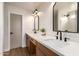Modern bathroom featuring a double sink vanity with quartz countertops, black fixtures, and contemporary mirrors at 3841 E Esplanade Ave, Gilbert, AZ 85297