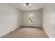 Well-lit, empty bedroom with neutral carpet, a window offering natural light, and fresh paint at 3841 E Esplanade Ave, Gilbert, AZ 85297