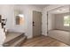 Bright entryway with hardwood and carpeted stairs, complemented by a light-filled window and neutral decor at 3841 E Esplanade Ave, Gilbert, AZ 85297
