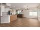 Bright kitchen with an island, stainless steel appliances, a window, and hardwood floors extending into the living area at 3841 E Esplanade Ave, Gilbert, AZ 85297