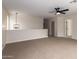 Spacious loft area with neutral carpeting, modern lighting, and doorways leading to other rooms at 3841 E Esplanade Ave, Gilbert, AZ 85297