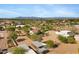 This aerial view showcases lush landscaping, a large horse area, and distant mountain views at 4187 E Triple Crown Dr, San Tan Valley, AZ 85140