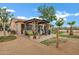 Backyard view with a pergola, seating, lush greenery, and desert landscaping at 4187 E Triple Crown Dr, San Tan Valley, AZ 85140